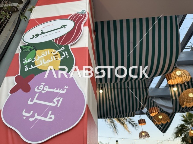 لوحة اعلانية بسوق جذور في حديقة الأمير سعود بمدينة الظهران، المنطقة الشرقية، المملكة العربية السعودية، منتجات حرفية وأطعمة منزلية، أركان تسوق خارجية ، فعاليات عائلية وأنشطة ترفيهية،  سوق مجتمعي مفتوح يدعم المشاريع المحلية، أجواء تراثية واجتماعية نابضة بالحياة