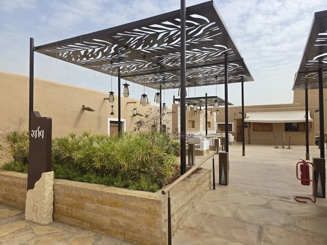 The historical heritage village in the city of Riyadh, the green palm trees, the old walls of Diriyah in the city of Riyadh in the Kingdom of Saudi Arabia, ancient historical archaeological landmarks, ancient architectural engineering art, a picture of the archaeological buildings and mud houses in the Al-Turaif neighborhood in Diriyah.