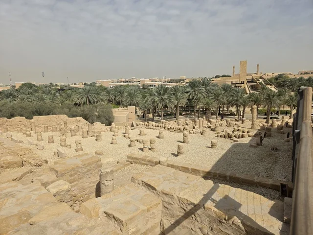 Clay structures built in the old style, green palm trees, the old walls of Diriyah in the city of Riyadh in the Kingdom of Saudi Arabia, ancient historical archaeological landmarks, ancient architectural engineering art, a picture of the archaeological buildings and clay houses in the Al-Turaif neighborhood in Diriyah.