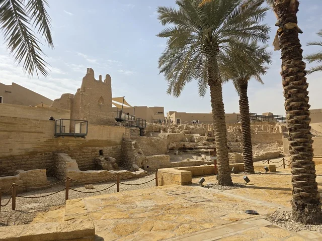 Cultivation of palm trees, ancient historical archaeological sites, the old walls of Diriyah in the city of Riyadh in the Kingdom of Saudi Arabia, ancient architectural engineering art, a picture of the archaeological buildings and mud houses in the Al-Turaif neighborhood in Diriyah, the history of the First Saudi State.