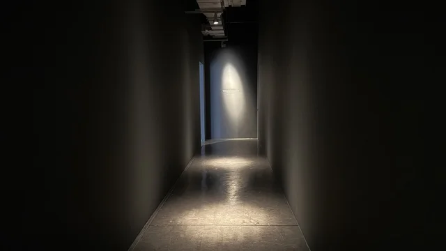 A dimly lit corridor in the animation exhibition in Jeddah, Saudi Arabia, an artistic and entertainment event dedicated to the world of animation, showcasing characters and cartoon works, interactive experiences and visual displays, educational and recreational activities for children and families, an atmosphere that combines art and technology.