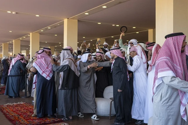 Expressions of enthusiasm and wide participation from camel owners, King Abdulaziz Camel Festival, Kingdom of Saudi Arabia, a major national heritage event, competitions and beauty of camels, shows and auctions, cultural and heritage activities, festive atmosphere reflecting the authenticity of the Saudi heritage.