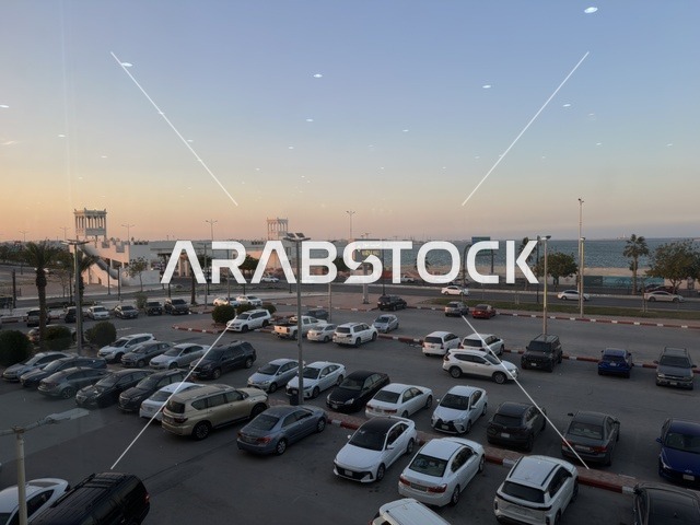 Parking in the outdoor parking lot of Marina Mall in Dammam, Eastern Province, Saudi Arabia, a shopping and entertainment center overlooking the waterfront, with various stores and brands, restaurants and cafes with sea views, recreational and service facilities, a family destination that combines shopping and entertainment.