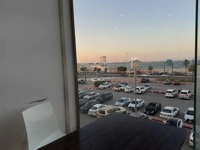 وقوف السيارات في الباركينج الخارجي لمارينا مول في مدينة الدمام، المنطقة الشرقية، المملكة العربية السعودية، مركز تسوق وترفيه مطل على الواجهة البحرية، متاجر وعلامات تجارية متنوعة، مطاعم ومقاهي بإطلالات بحرية، مرافق ترفيهية وخدمية، وجهة عائلية تجمع التسوق والترفيه