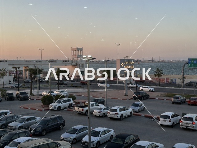 وقوف السيارات في الباركينج الخارجي لمارينا مول في مدينة الدمام، المنطقة الشرقية، المملكة العربية السعودية، مركز تسوق وترفيه مطل على الواجهة البحرية، متاجر وعلامات تجارية متنوعة، مطاعم ومقاهي بإطلالات بحرية، مرافق ترفيهية وخدمية، وجهة عائلية تجمع التسوق والترفيه
