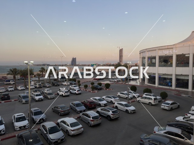 وقوف السيارات في الباركينج الخارجي لمارينا مول في مدينة الدمام، المنطقة الشرقية، المملكة العربية السعودية، مركز تسوق وترفيه مطل على الواجهة البحرية، متاجر وعلامات تجارية متنوعة، مطاعم ومقاهي بإطلالات بحرية، مرافق ترفيهية وخدمية، وجهة عائلية تجمع التسوق والترفيه