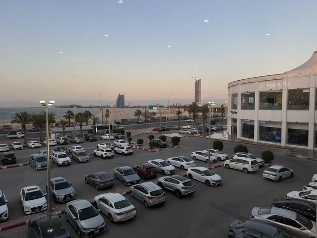 Parking in the outdoor parking lot of Marina Mall in Dammam, Eastern Province, Saudi Arabia, a shopping and entertainment center overlooking the waterfront, with various stores and brands, restaurants and cafes with sea views, recreational and service facilities, a family destination that combines shopping and entertainment.