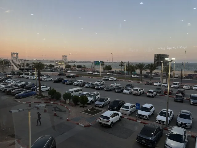 وقوف السيارات في الباركينج الخارجي لمارينا مول في مدينة الدمام، المنطقة الشرقية، المملكة العربية السعودية، مركز تسوق وترفيه مطل على الواجهة البحرية، متاجر وعلامات تجارية متنوعة، مطاعم ومقاهي بإطلالات بحرية، مرافق ترفيهية وخدمية، وجهة عائلية تجمع التسوق والترفيه