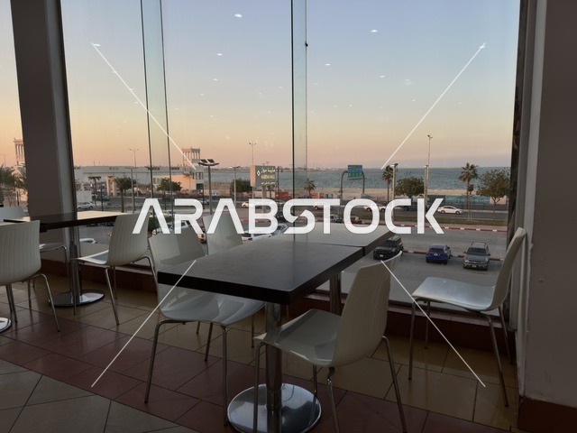 A view from the windows of a café in Marina Mall in Dammam, Eastern Province, Saudi Arabia, a shopping and entertainment center overlooking the waterfront, with various shops and brands, restaurants and cafés with sea views, recreational and service facilities, a family destination that combines shopping and entertainment.