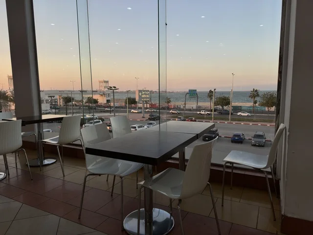 A view from the windows of a café in Marina Mall in Dammam, Eastern Province, Saudi Arabia, a shopping and entertainment center overlooking the waterfront, with various shops and brands, restaurants and cafés with sea views, recreational and service facilities, a family destination that combines shopping and entertainment.