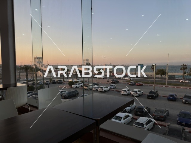 A view from the windows of a café in Marina Mall in Dammam, Eastern Province, Saudi Arabia, a shopping and entertainment center overlooking the waterfront, with various shops and brands, restaurants and cafés with sea views, recreational and service facilities, a family destination that combines shopping and entertainment.