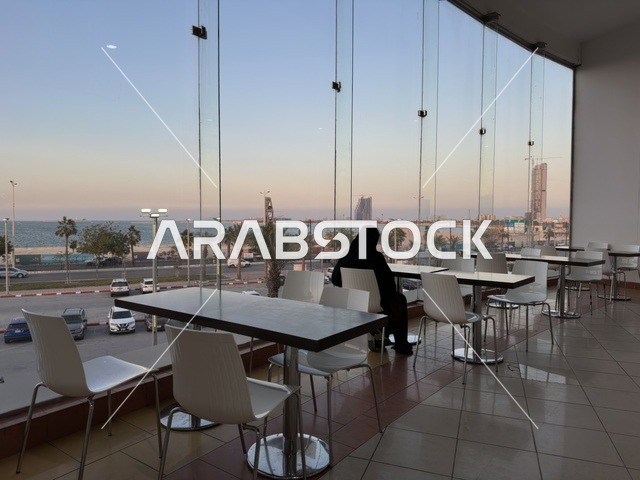 A view from the windows of a café in Marina Mall in Dammam, Eastern Province, Saudi Arabia, a shopping and entertainment center overlooking the waterfront, with various shops and brands, restaurants and cafés with sea views, recreational and service facilities, a family destination that combines shopping and entertainment.
