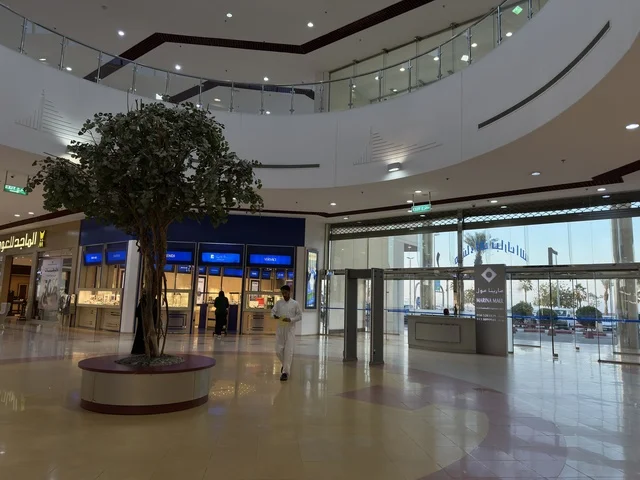 التصميم الداخلي لمبني مارينا مول في مدينة الدمام، المنطقة الشرقية، المملكة العربية السعودية، مركز تسوق وترفيه مطل على الواجهة البحرية، متاجر وعلامات تجارية متنوعة، مطاعم ومقاهي بإطلالات بحرية، مرافق ترفيهية وخدمية، وجهة عائلية تجمع التسوق والترفيه