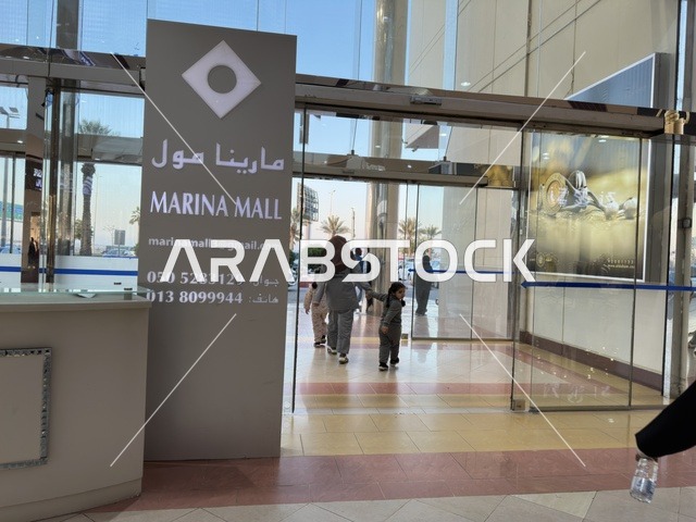 مدخل مارينا مول في مدينة الدمام، المنطقة الشرقية، المملكة العربية السعودية، مركز تسوق وترفيه مطل على الواجهة البحرية، متاجر وعلامات تجارية متنوعة، مطاعم ومقاهي بإطلالات بحرية، مرافق ترفيهية وخدمية، وجهة عائلية تجمع التسوق والترفيه