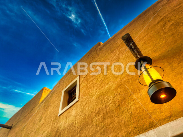 An aesthetic image of a lantern hanging on one of the old Diriyah buildings in the city of Riyadh, Al-Bujairi Heritage Village, a historical tourist interface in the Kingdom of Saudi Arabia