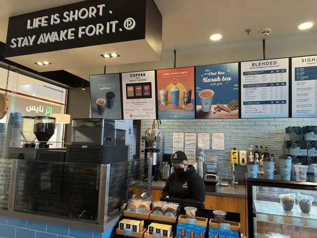 كوفي ومقهي في مارينا مول في مدينة الدمام، المنطقة الشرقية، المملكة العربية السعودية، مركز تسوق وترفيه مطل على الواجهة البحرية، متاجر وعلامات تجارية متنوعة، مطاعم ومقاهي بإطلالات بحرية، مرافق ترفيهية وخدمية، وجهة عائلية تجمع التسوق والترفيه