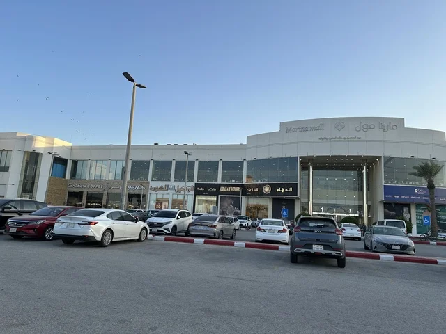 وقوف السيارات فى الباركينج الخارجي امام مارينا مول في مدينة الدمام، المنطقة الشرقية، المملكة العربية السعودية، مركز تسوق وترفيه مطل على الواجهة البحرية، متاجر وعلامات تجارية متنوعة، مطاعم ومقاهي بإطلالات بحرية، مرافق ترفيهية وخدمية، وجهة عائلية تجمع التسوق والترفيه