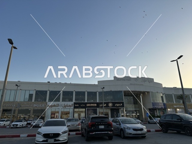 Parking in the outdoor parking lot in front of Marina Mall in Dammam, Eastern Province, Saudi Arabia, a shopping and entertainment center overlooking the waterfront, with various stores and brands, restaurants and cafes with sea views, recreational and service facilities, a family destination that combines shopping and entertainment.