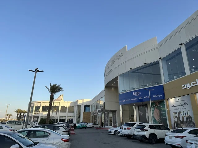 انتظار السيارات في المواقف الخارجية لمارينا مول في مدينة الدمام، المنطقة الشرقية، المملكة العربية السعودية، مركز تسوق وترفيه مطل على الواجهة البحرية، متاجر وعلامات تجارية متنوعة، مطاعم ومقاهي بإطلالات بحرية، مرافق ترفيهية وخدمية، وجهة عائلية تجمع التسوق والترفيه