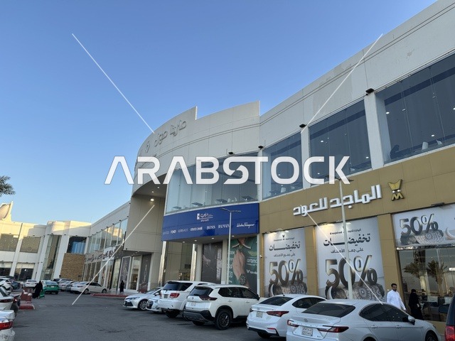 انتظار السيارات في المواقف الخارجية لمارينا مول في مدينة الدمام، المنطقة الشرقية، المملكة العربية السعودية، مركز تسوق وترفيه مطل على الواجهة البحرية، متاجر وعلامات تجارية متنوعة، مطاعم ومقاهي بإطلالات بحرية، مرافق ترفيهية وخدمية، وجهة عائلية تجمع التسوق والترفيه