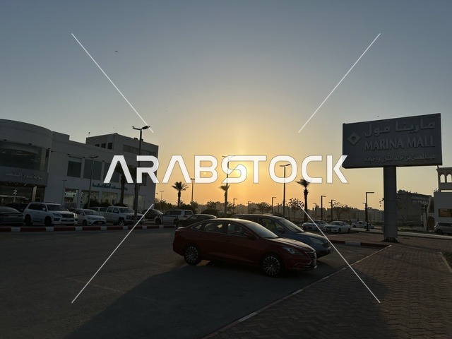 انتظار السيارات في المواقف الخارجية لمارينا مول في مدينة الدمام، المنطقة الشرقية، المملكة العربية السعودية، مركز تسوق وترفيه مطل على الواجهة البحرية، متاجر وعلامات تجارية متنوعة، مطاعم ومقاهي بإطلالات بحرية، مرافق ترفيهية وخدمية، وجهة عائلية تجمع التسوق والترفيه