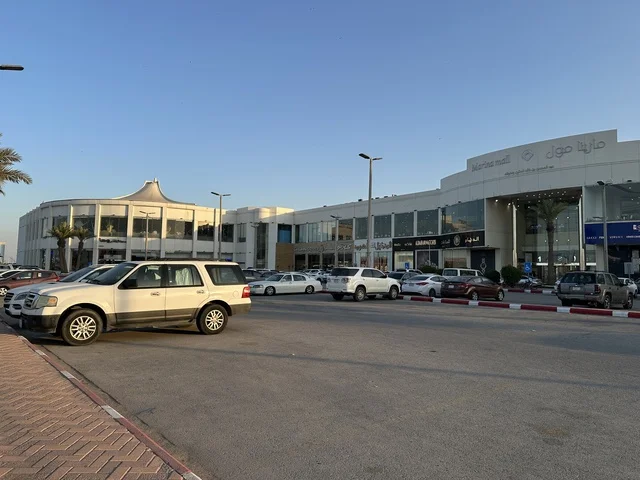 Parking for cars in the outdoor lots of Marina Mall in Dammam, Eastern Province, Saudi Arabia, a shopping and entertainment center overlooking the waterfront, with various stores and brands, restaurants and cafes with sea views, recreational and service facilities, a family destination that combines shopping and entertainment.