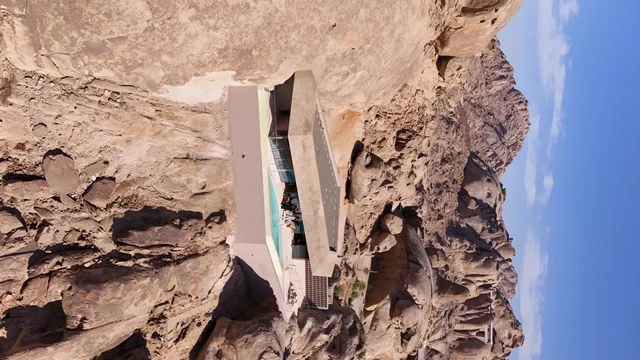 A global tourist destination, a mountain resort integrated with the rocky nature, Desert Rock in the Kingdom of Saudi Arabia, features innovative architectural design carved into the mountains, offering a unique tourism experience that combines luxury and sustainability, with stunning desert views.