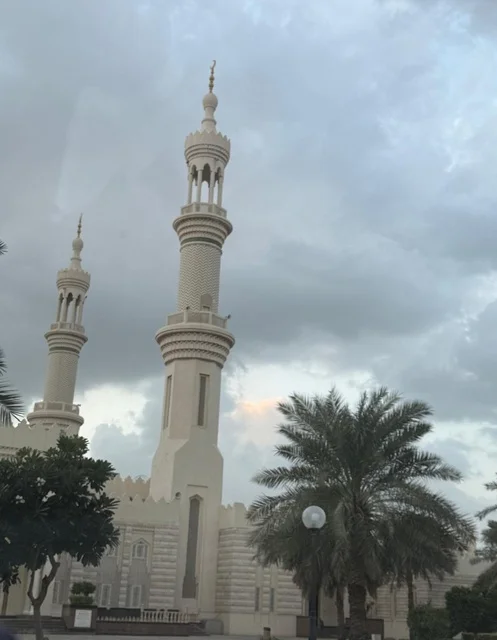 The minarets of Sheikh Zayed Mosque in Ajman, United Arab Emirates, winter atmosphere with a view of the cloudy sky, architectural art, tranquility, and spirituality.