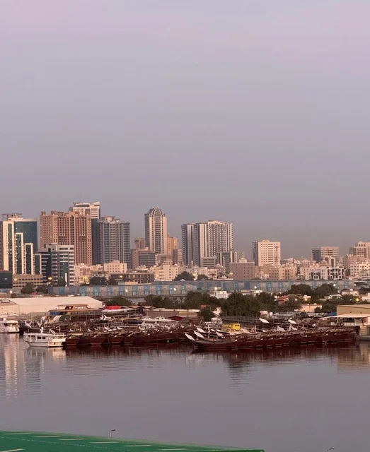 القوارب الخشبية التقليدية في ميناء عجمان، دولة الإمارات العربية المتحدة، تراث بحري أصيل، مراكب مصطفّة على الميناء، مشهد يعكس تاريخ الملاحة والصيد في الإمارات