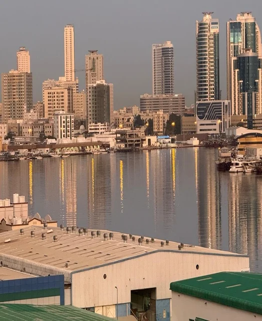 انعكاس الأبراج الحديثة على مياه البحر في دولة الإمارات العربية المتحدة، مشهد حضري أنيق، تداخل العمارة المعاصرة مع الطبيعة البحرية،  تطور المدن الساحلية.