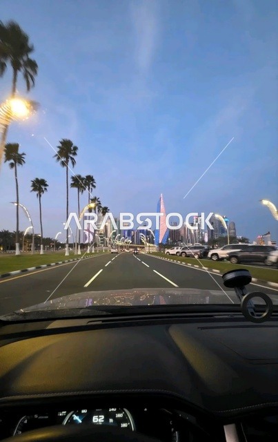 A picture of the entrance to one of the cities in the State of Qatar from inside the car, a modern road and architectural landmarks, an urban scene reflecting development and modern infrastructure.