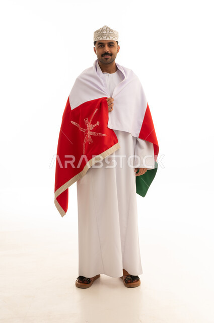 رجل عماني بالزي التقليدي يرتدي العلم الوطني