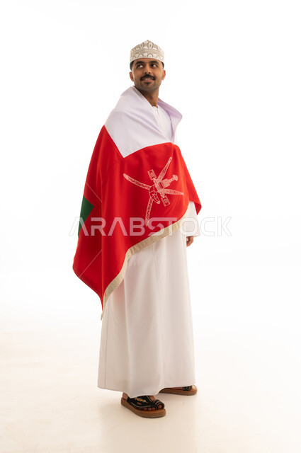 رجل عماني باللباس التقليدي مع علم سلطنة عمان