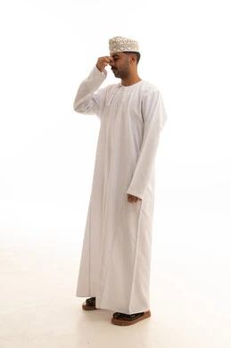 رجل عماني بالزي التقليدي أمام خلفية بيضاء