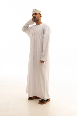 رجل عماني بالدشداشة التقليدية والكمة خلفية بيضاء