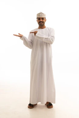 رجل عُماني بالزي التقليدي يشير للخلفية البيضاء