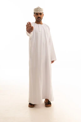 رجل عماني بالزي التقليدي يشير بعلامة التوقف