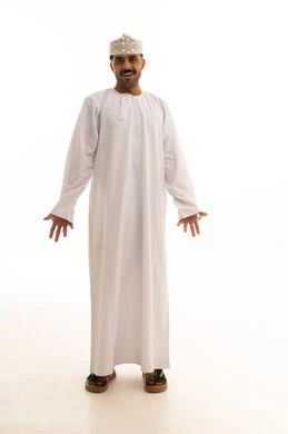 رجل عُماني بالزي التقليدي يبتسم أمام خلفية بيضاء
