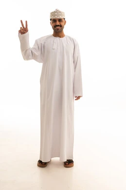 رجل عماني بالزي التقليدي يرفع علامة النصر