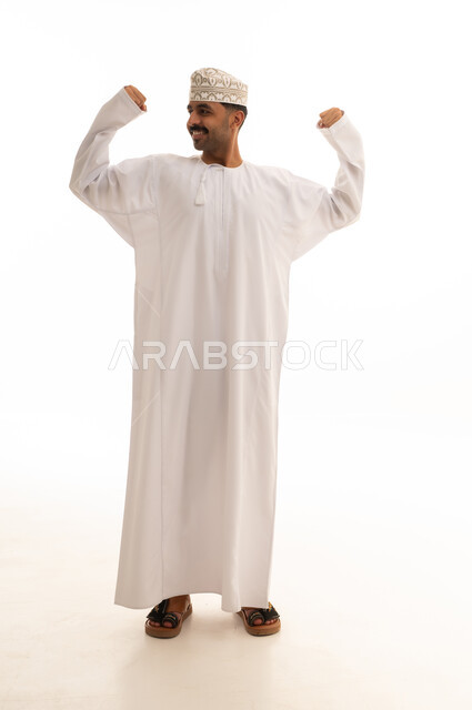 رجل عماني بالزي التقليدي يستعرض عضلاته