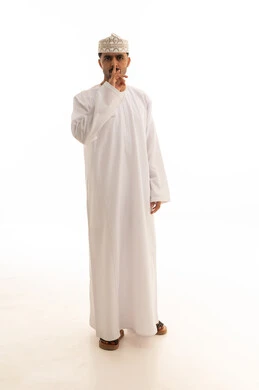 رجل عماني بالزي التقليدي يشير بعلامة الصمت