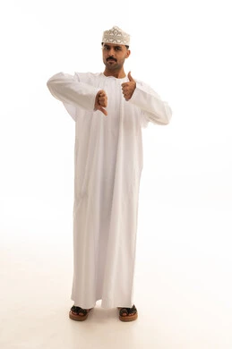 رجل عماني يظهر إشارة الإعجاب وعدم الإعجاب بخلفية بيضاء