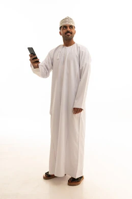 رجل عماني بالزي التقليدي يحمل هاتف ذكي