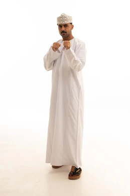 رجل عماني بالزي التقليدي في وضعية ملاكمة خلفية بيضاء