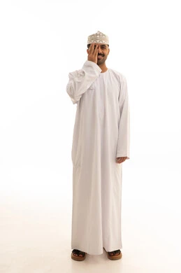 رجل عماني بالزي التقليدي أمام خلفية بيضاء
