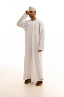رجل عماني بالزي التقليدي أمام خلفية بيضاء