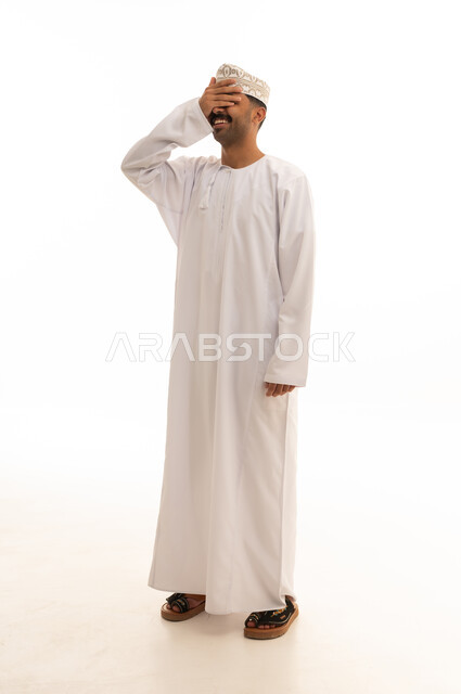 رجل عماني بالزي التقليدي يغطي عينيه خلفية بيضاء