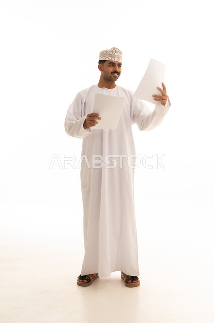 Omani Man in Traditional Dress Reading Documents