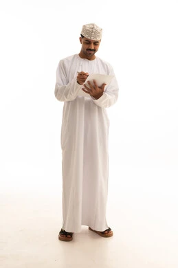 رجل عماني بالزي التقليدي يكتب أمام خلفية بيضاء