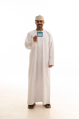 رجل عماني بالزي التقليدي يحمل بطاقة هوية